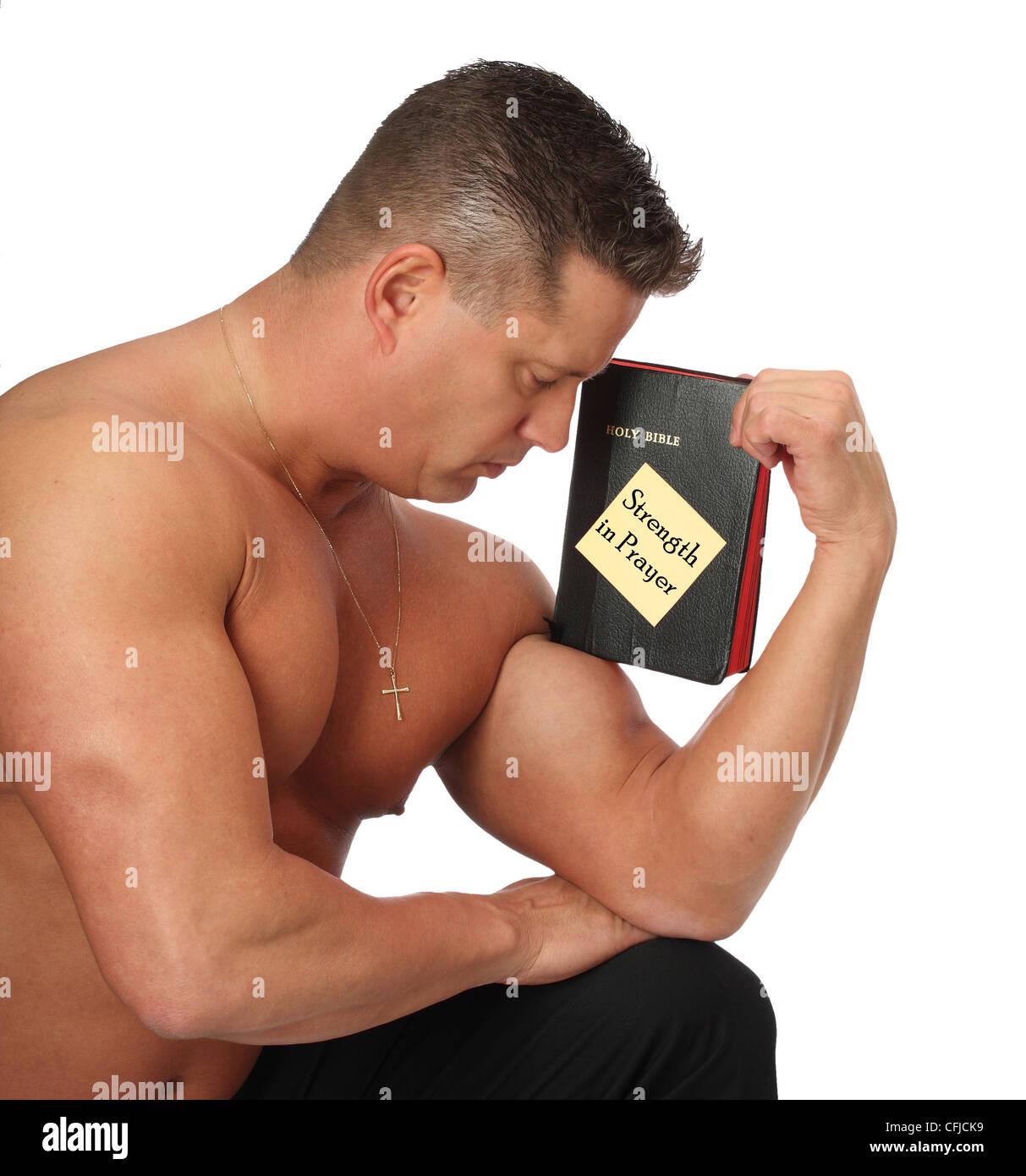 Kraftprotz mit Bibel im Gebet Stockfoto