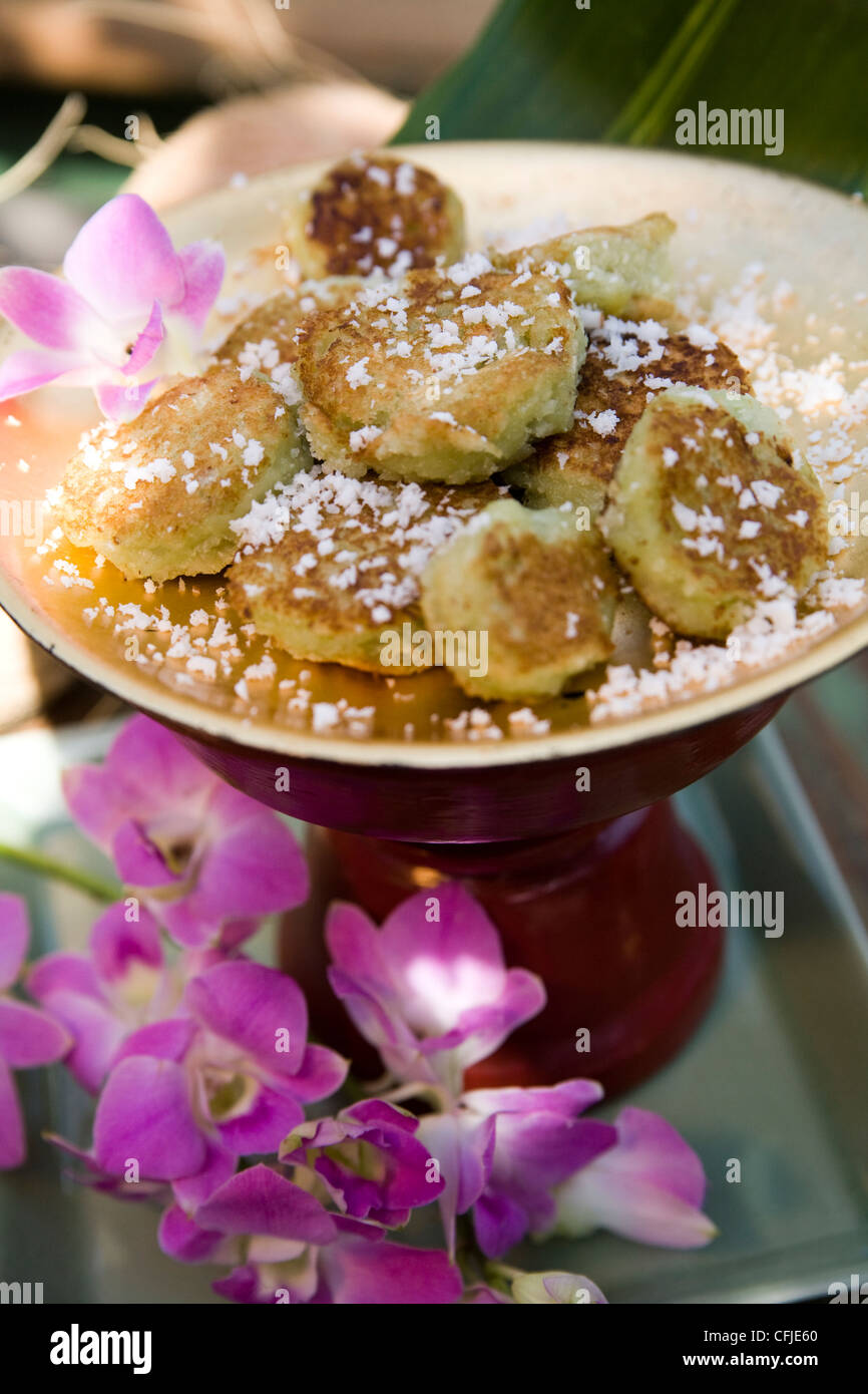 Thailändische Kokos-Cookies, bestäubt mit Puderzucker serviert in einem traditionellen Ambiente Stockfoto
