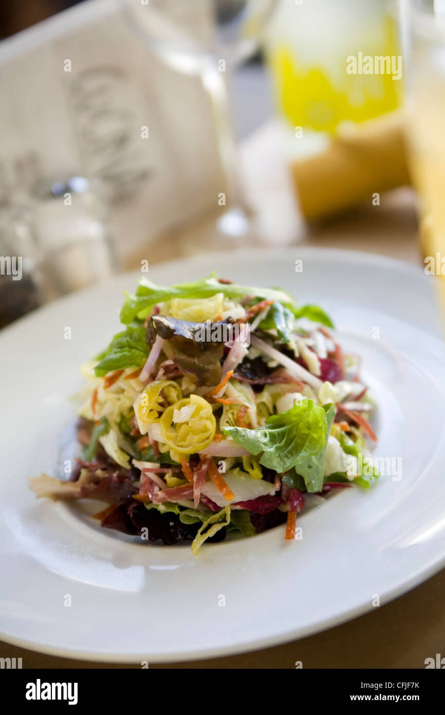 Frischen gehackten Salat auf einem hellen weißen Teller in ein modernes café Stockfoto