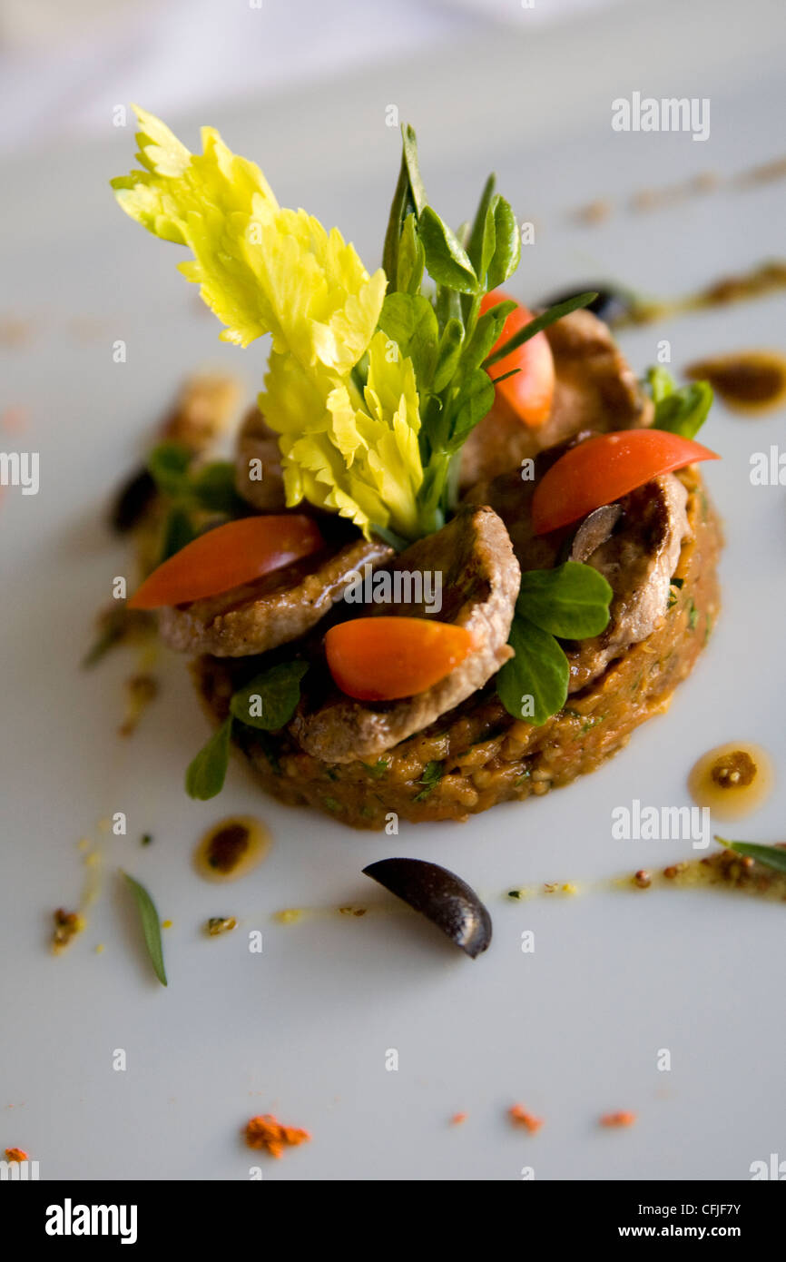 Französische Linsen vegetarische Vorspeise mit Sellerie-Federn, Oliven Tapenade, Brunnenkresse, Tomatenscheiben und frischen Kräutern Stockfoto