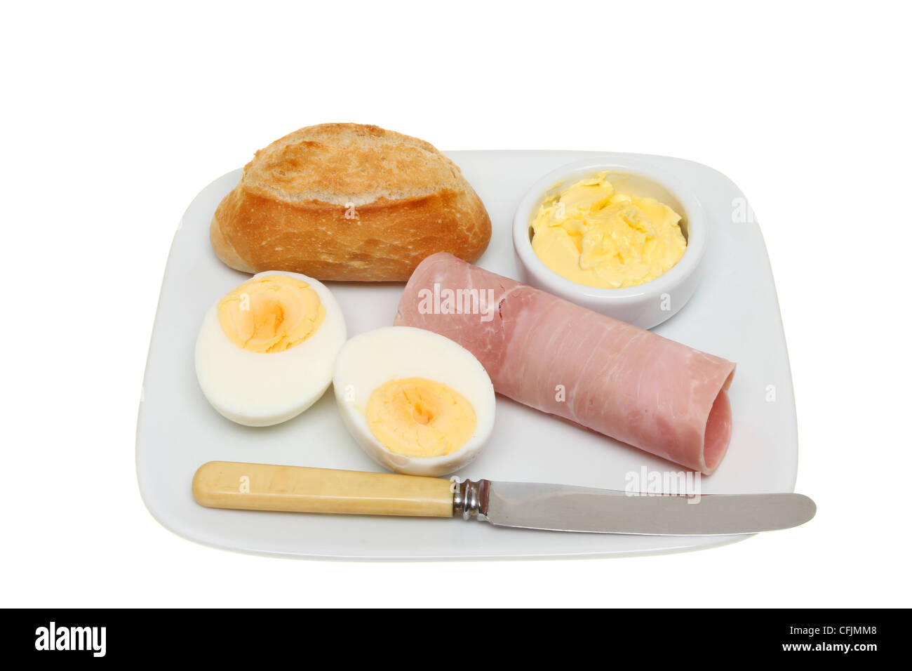 Brötchen, Ei und Schinken mit Butter und ein Messer auf einem Teller isoliert gegen weiß Stockfoto