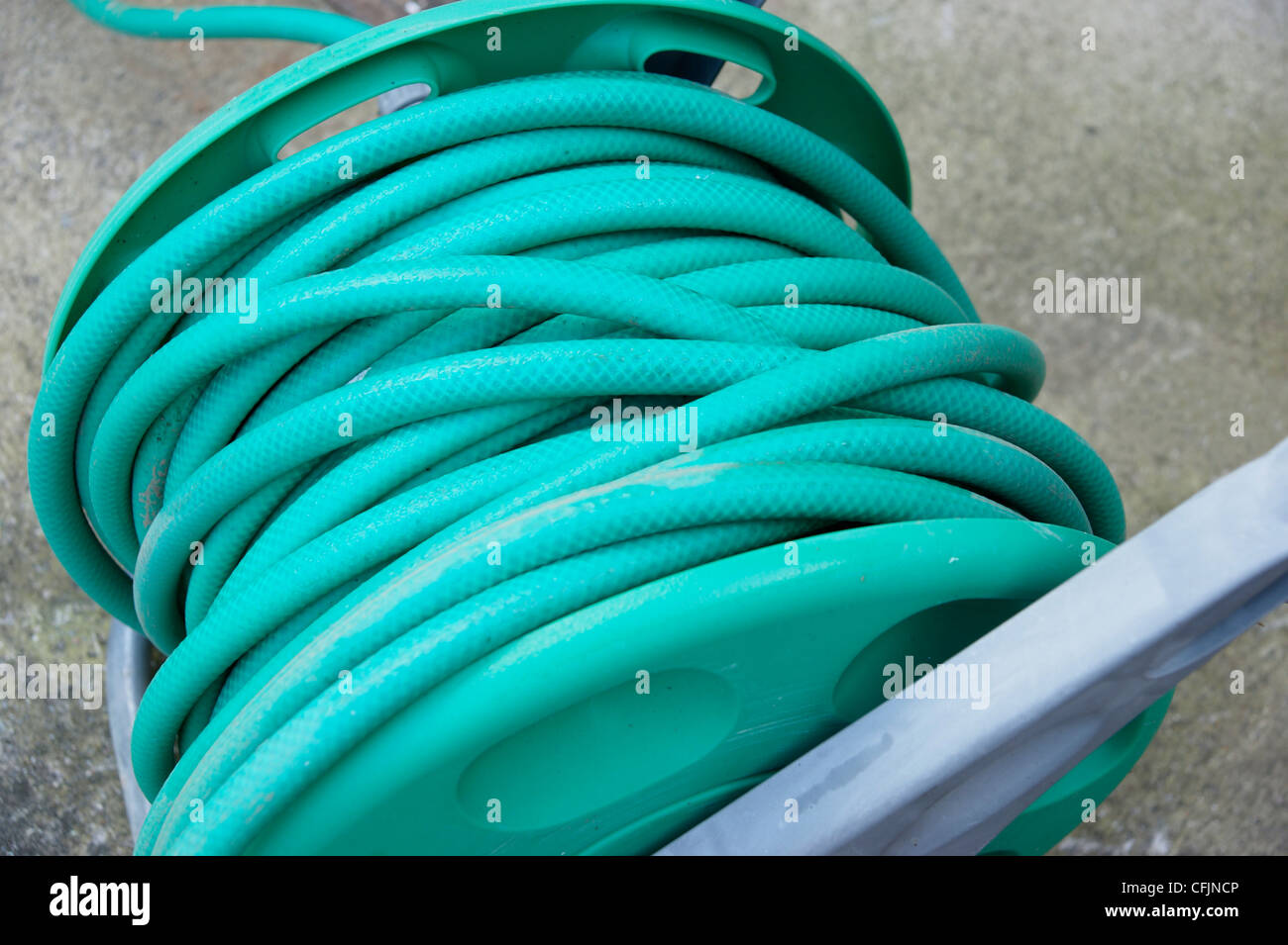 Schlauchleitung auf eine Rolle im Garten legen ruhenden mit dem Gartenschlauch Ban in vielen Bereichen des Landes Stockfoto