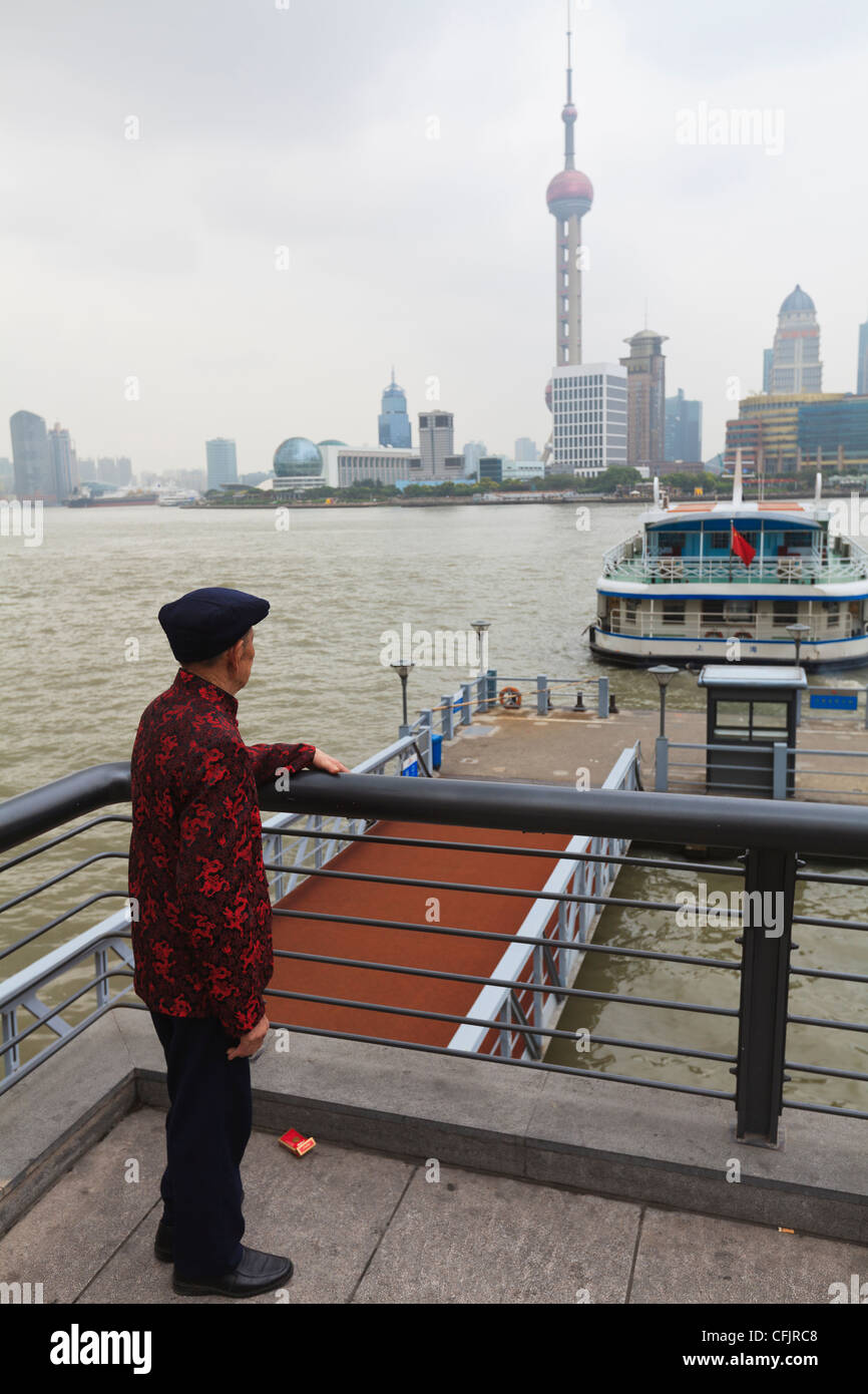 Ein Mann beobachtet Fähren überqueren die Fluss Huangpu, Shanghai, China, Asien Stockfoto