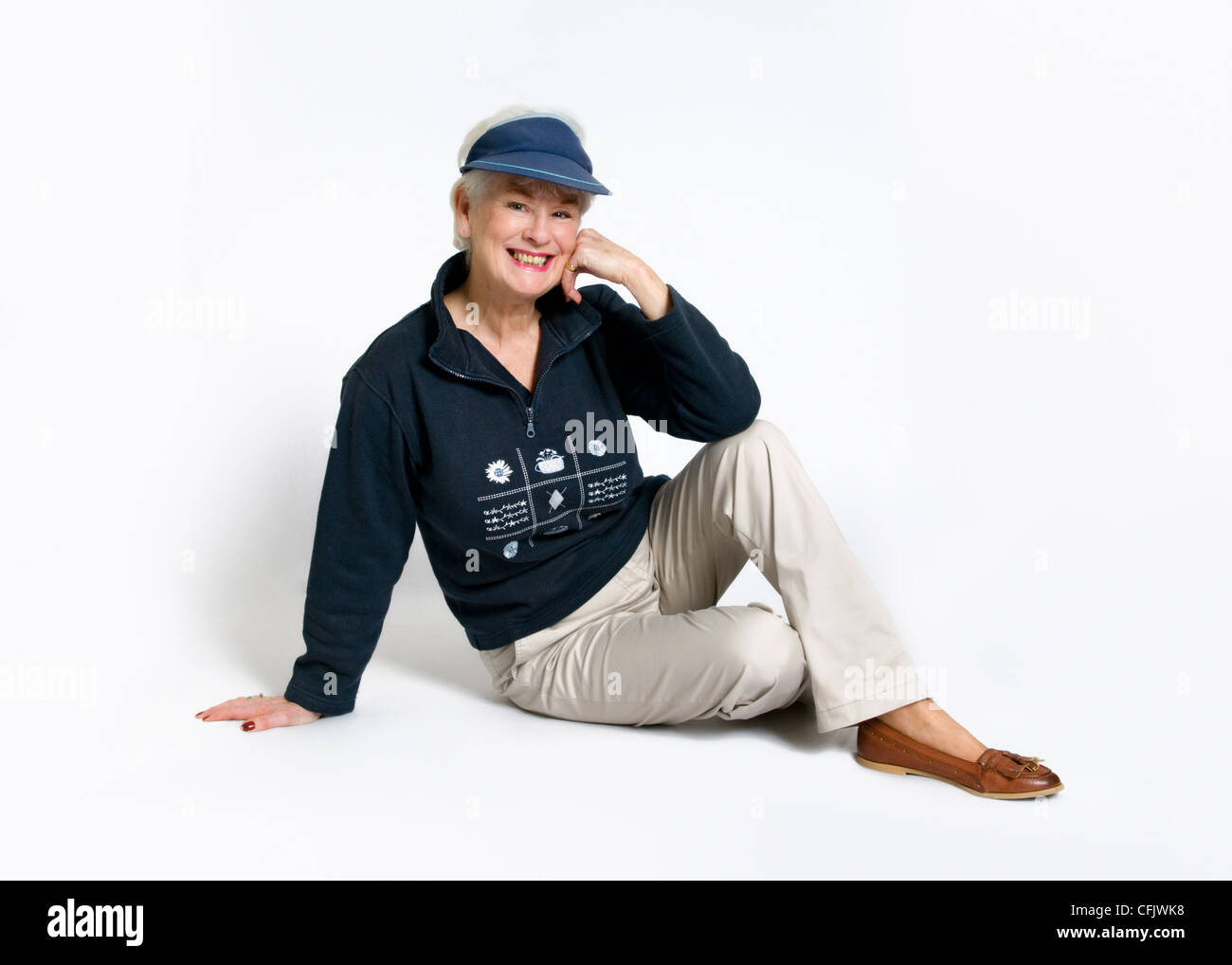 Attraktive ältere Dame lächelnd in casual Outdoor Kleidung gegen einen weißen Hintergrund Stockfoto