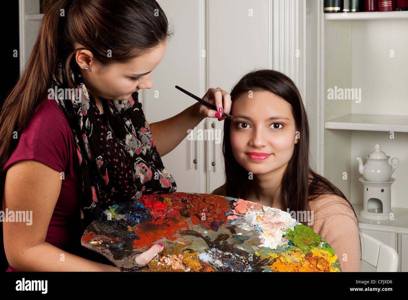 Lustige Visagistin arbeitet mit einem Maler Palet in ihren Händen Stockfoto