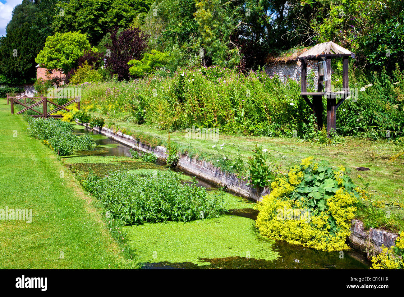 Eine ornamentale Rill und Holzsteg in den englischen Garten der Rasenflächen Landsitz in Berkshire, England, UK Stockfoto