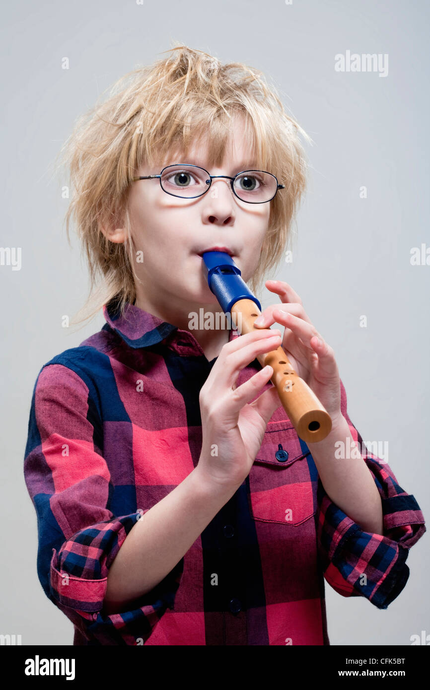 Junge mit Brille sein Flötenspiel - isoliert auf grau Stockfoto