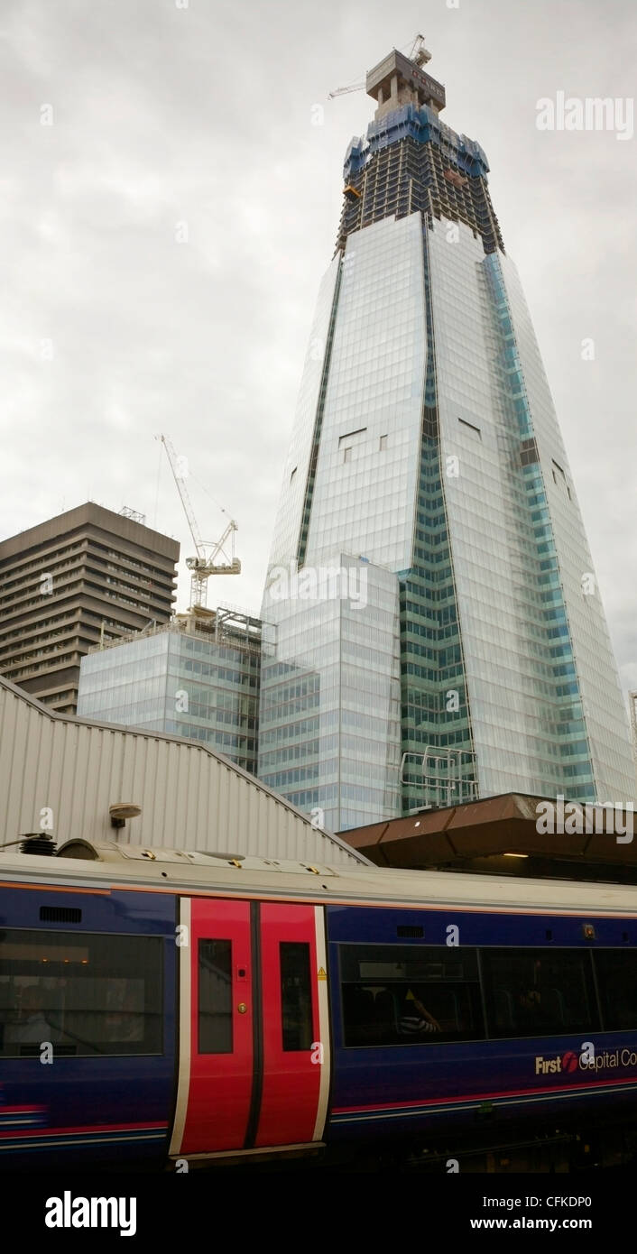 Eine stationäre Zug am Bahnhof London Bridge und Shard Gebäude im Bau, UK. Stockfoto