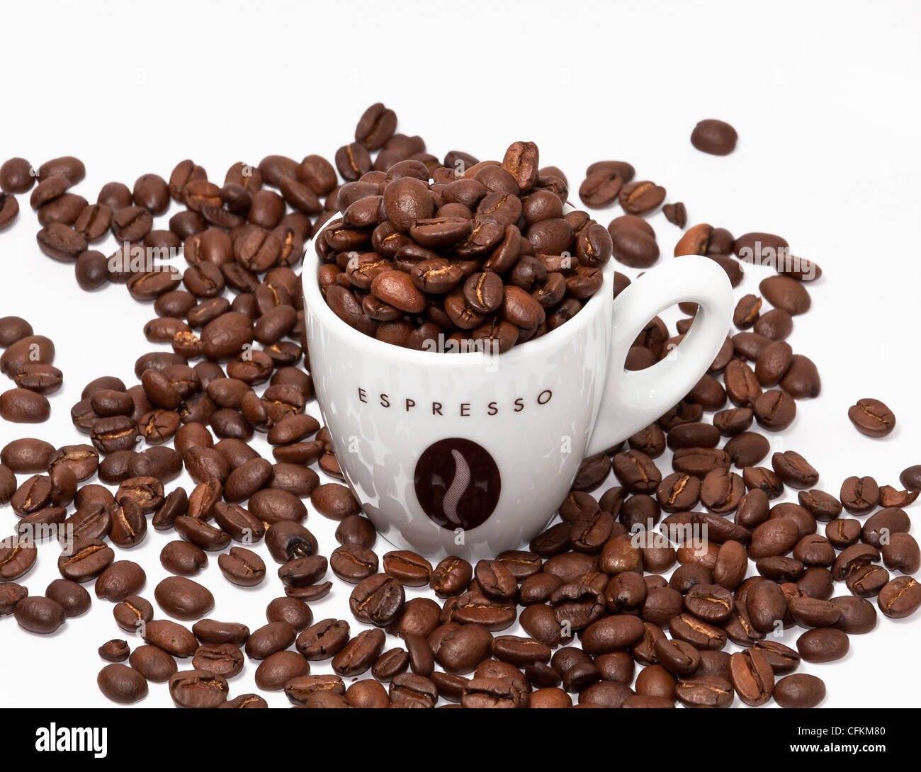 Espressotasse und Kaffeebohnen auf weißem Hintergrund. Stockfoto