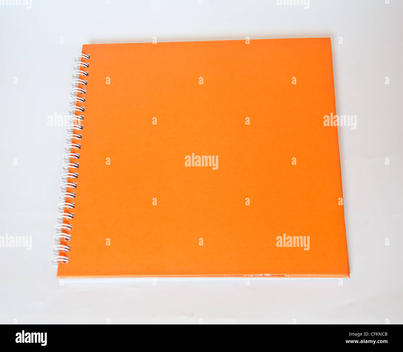 Orange Notebook auf weißem Hintergrund Stockfoto