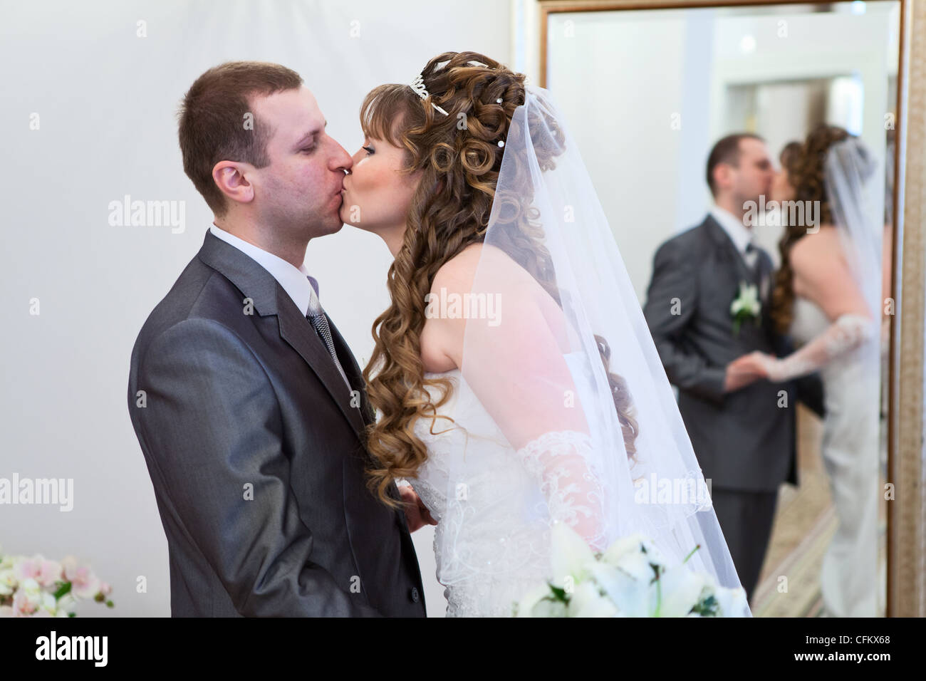 Junges, kaukasische russische Hochzeit paar küssen zusammen. Reflexion