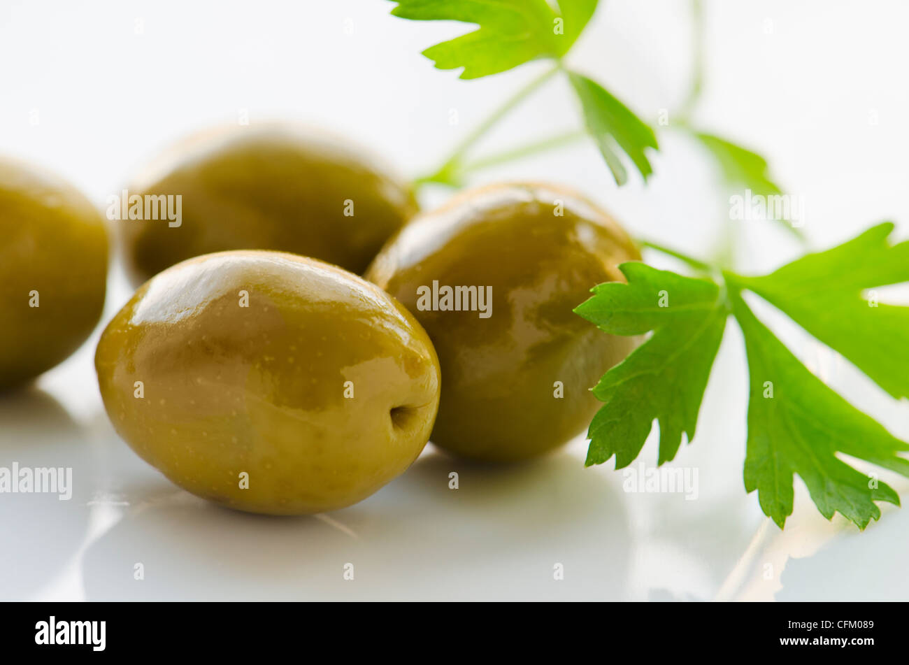 Grüne Oliven mit frischer Petersilie, Studio gedreht in Nahaufnahme Stockfoto