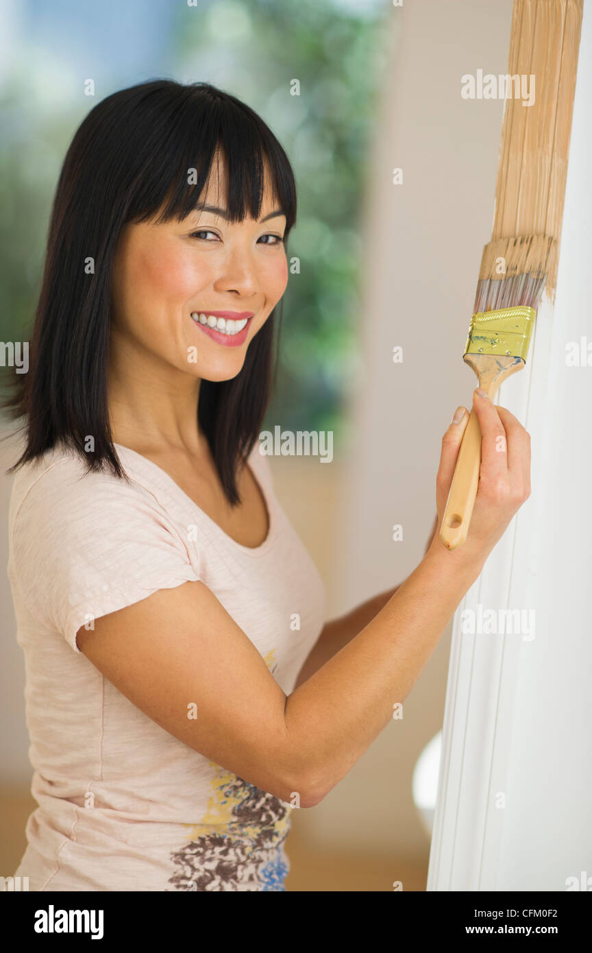 USA, New Jersey, Jersey City, Smiling Frau Malerei Türrahmen Stockfoto