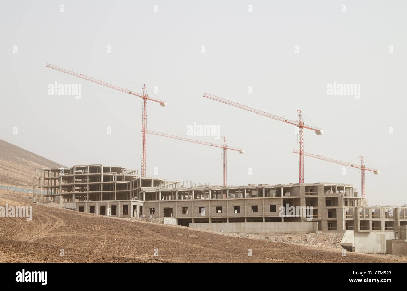 Krane über verlassene Baustelle (Hotel an der Küste) auf Fuerteventura, Kanarische Inseln, Spanien Stockfoto