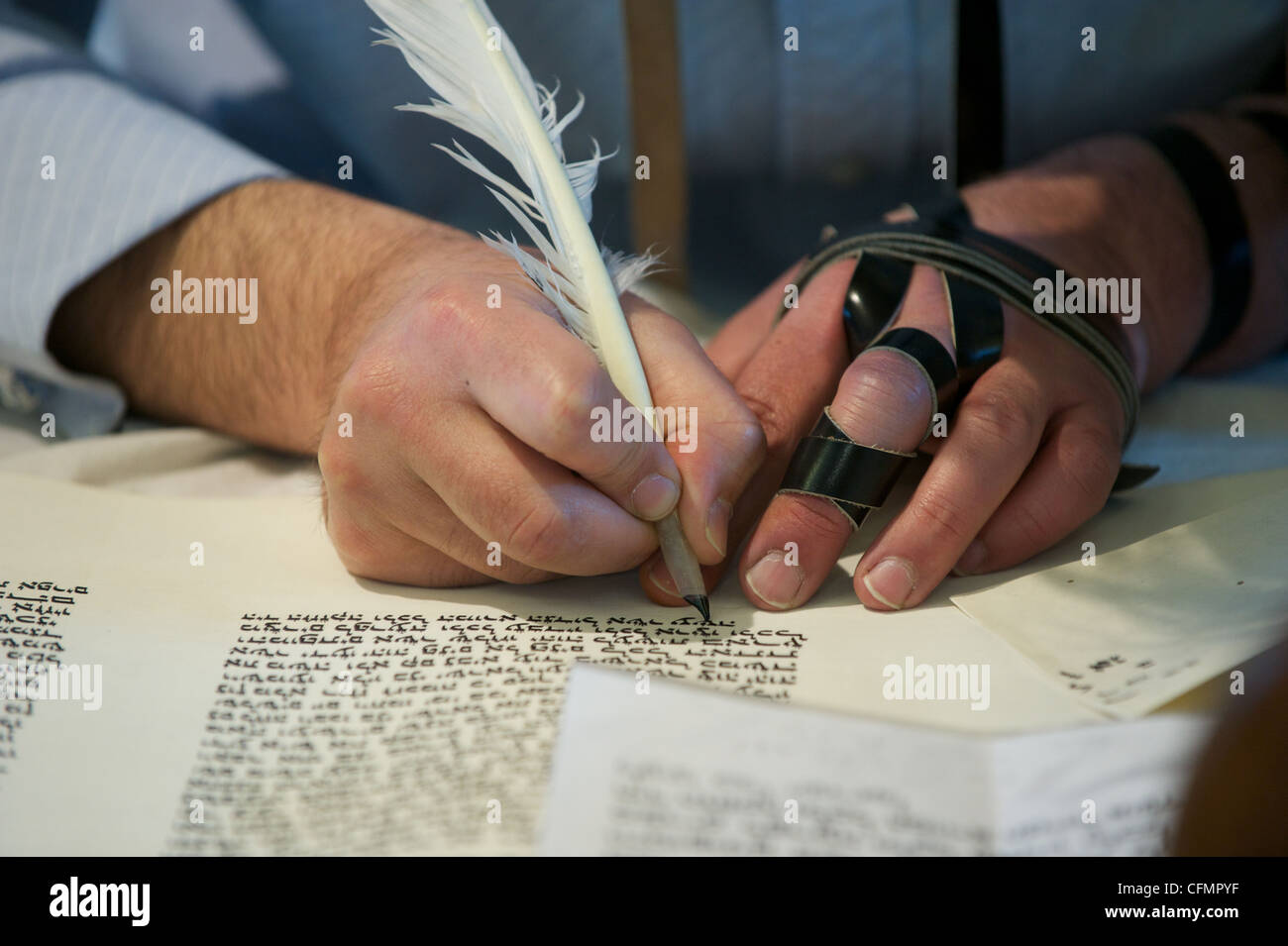 Eine jüdische Schreiber, bekannt als ein Sopher hebräische Buchstaben auf Pergament bilden eine neue Sefer Tora-Rolle zu schreiben.  Tefillin tragen. Stockfoto