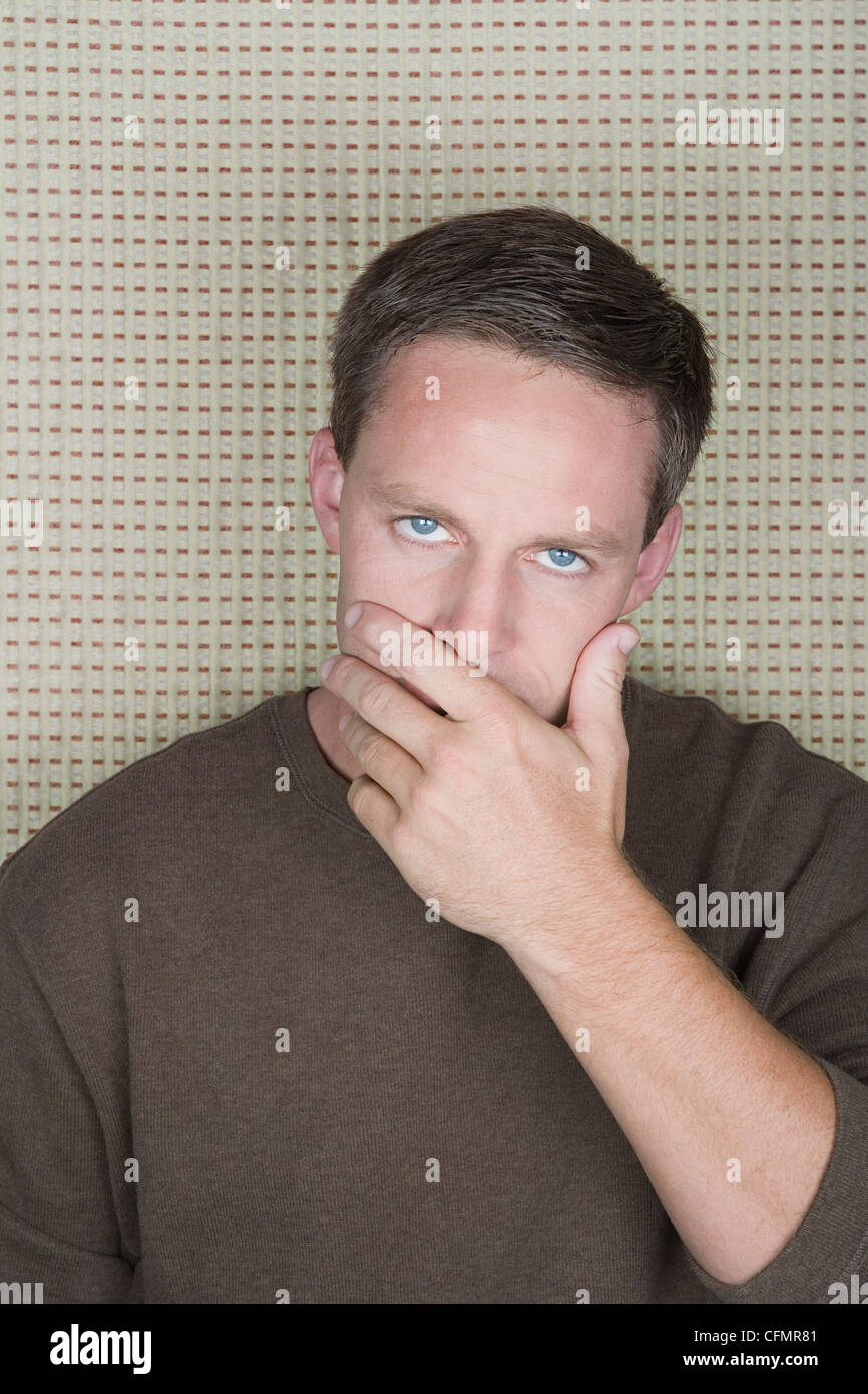 Studioportrait von reifer Mann den Mund mit der hand Stockfoto