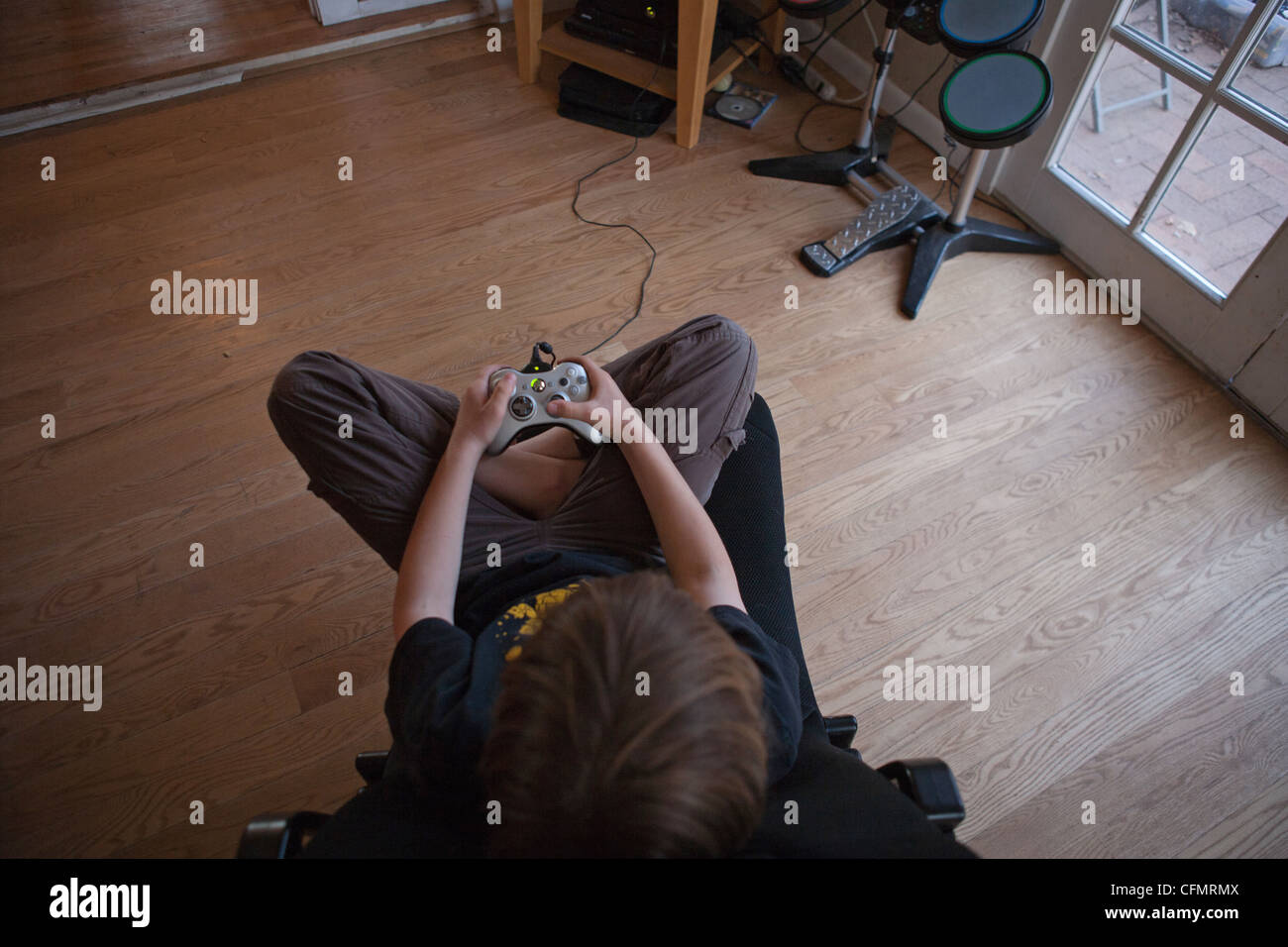 Neun Jahre alten Jungen ein Videospiel mit einer Xbox 360 Steuerung zu Hause im Wohnzimmer spielen. Stockfoto