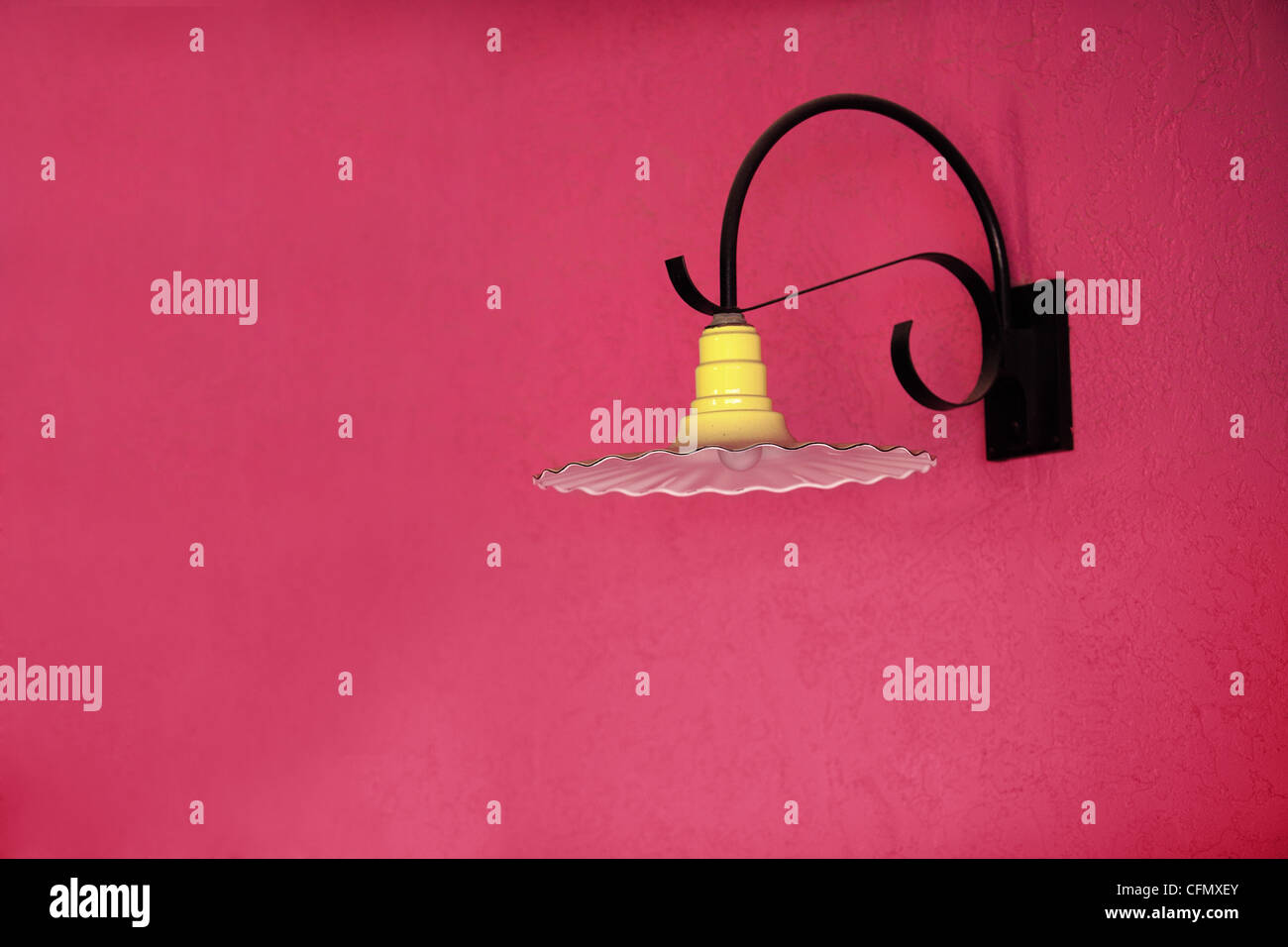 Eine Südwestart Leuchte an einem Magenta Stuck Wand hängen. Stockfoto