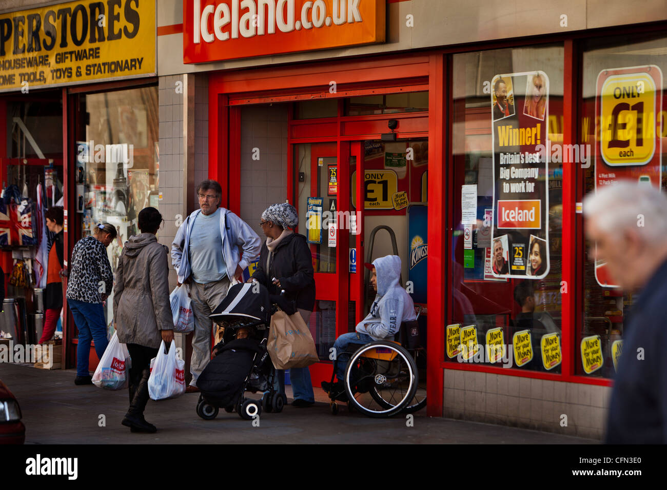 Käufer außerhalb Islands Nahrung speichern auf King Street, Hammersmith, London, auf einem Sonntag Nachmittag-Shop. Stockfoto