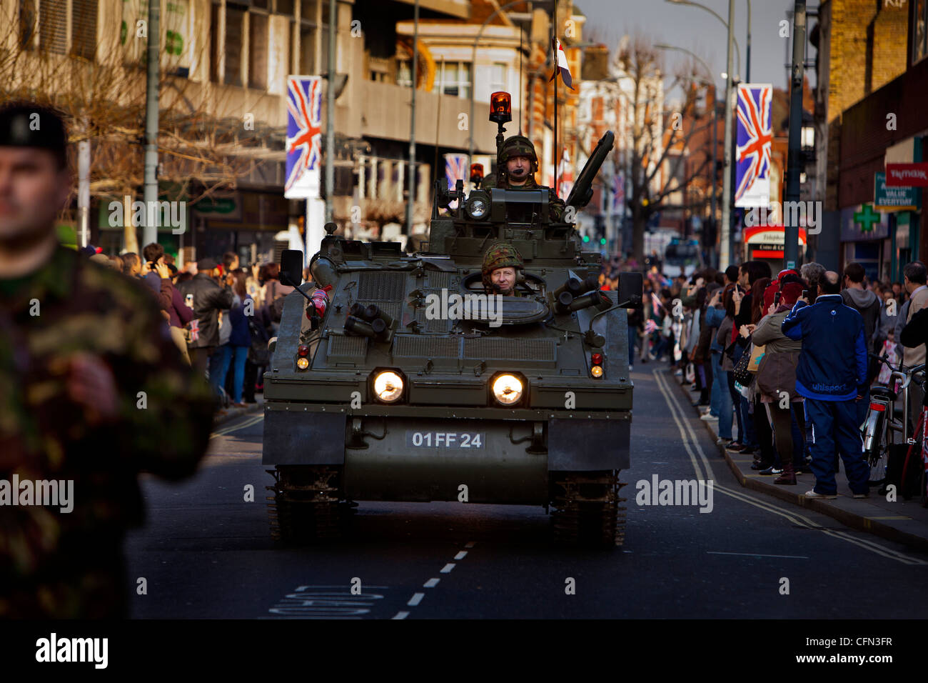 Truppen in gepanzerten Fahrzeugen vorbeifahren High Street Läden während einer königlichen Yeomanry Parade beobachten Zuschauer vom Gehsteig Stockfoto