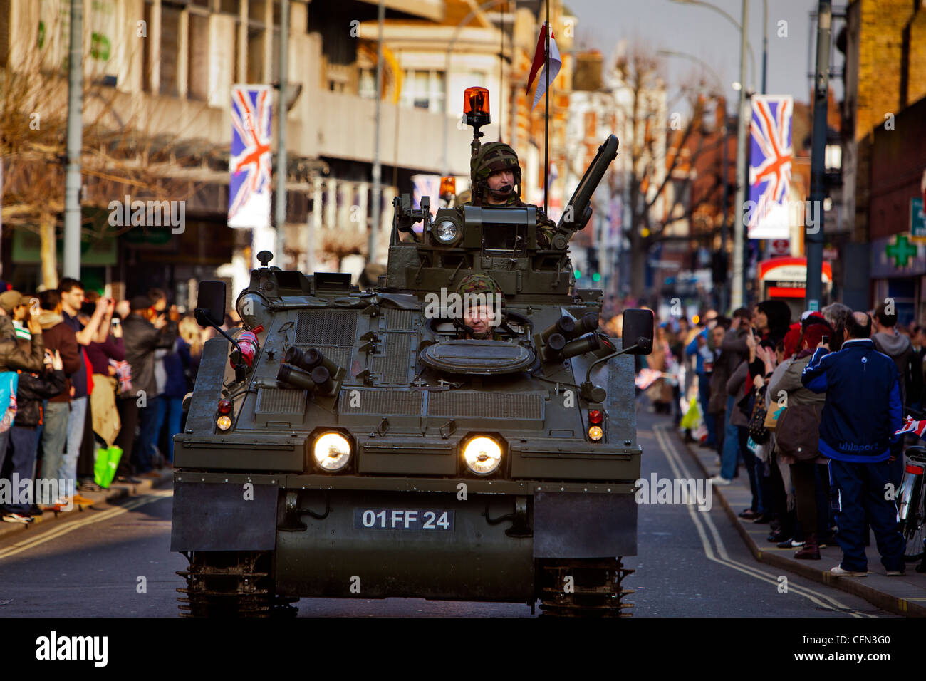 Truppen in gepanzerten Fahrzeugen vorbeifahren High Street Läden während einer königlichen Yeomanry Parade beobachten Zuschauer vom Gehsteig Stockfoto