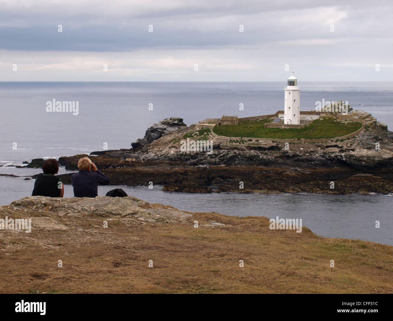 Zwei Wanderer, Blick auf Leuchtturm von Godrevy, St Ives Bay, Cornwall, UK Stockfoto