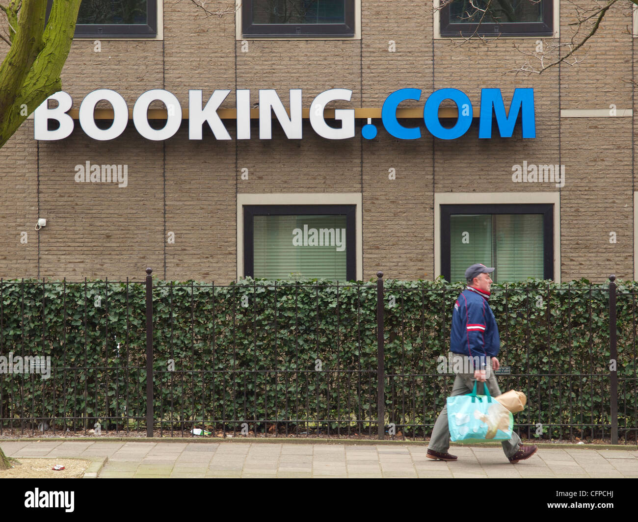 Booking.com-Büros in Amsterdam, die Niederlande mit Mann vorbeigehen Stockfoto