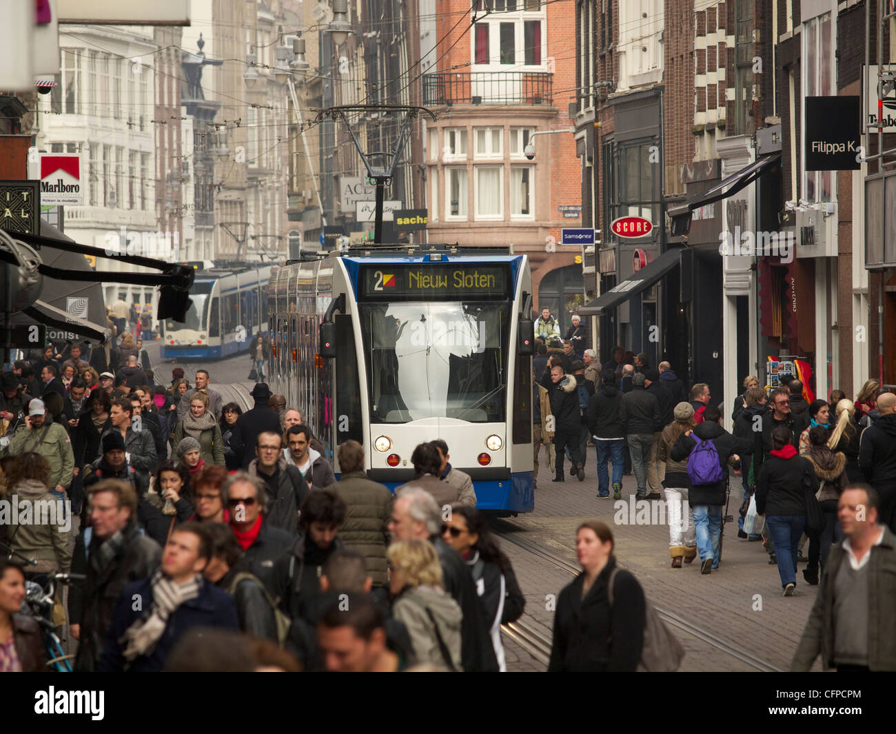 eine überfüllte Leidsestraat Einkaufsstraße, Amsterdam Niederlande mit vorbeifahrenden Straßenbahnlinie 2 Stockfoto