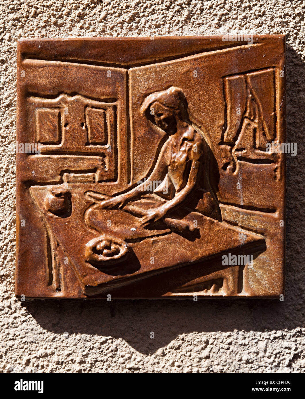 Keramik-Symbol der Frau Backset in Wand der Konditorei Bäcker, Olargues, Herault, haute Languedoc, Frankreich Stockfoto