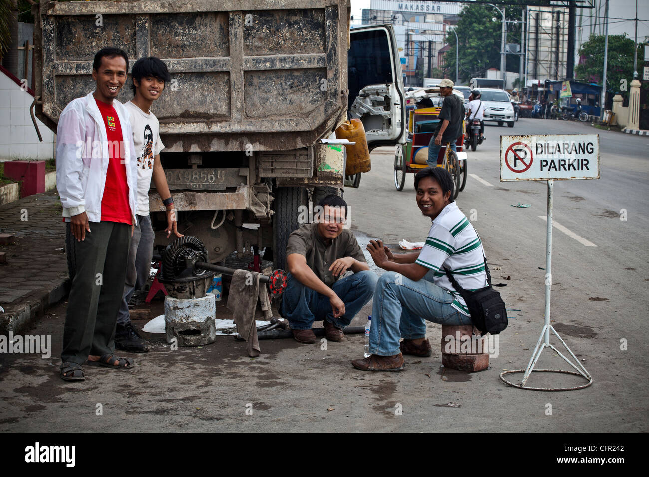 Männer, die Reparatur eines defekten LKW in einer Straße von Makassar (Ujung Pandang), Sulawesi, Indonesien, Süd-Pazifik, Asien. Stockfoto