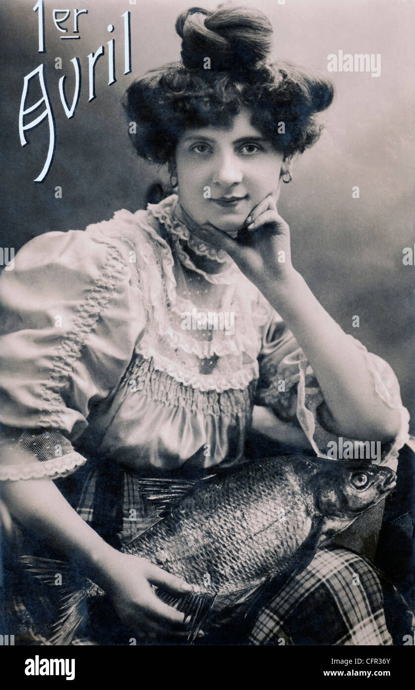 Vintage-Fotopostkarte einer Frau, die einen Fisch in der Hand hält, Apriltag, Frankreich, um 1900. Stockfoto