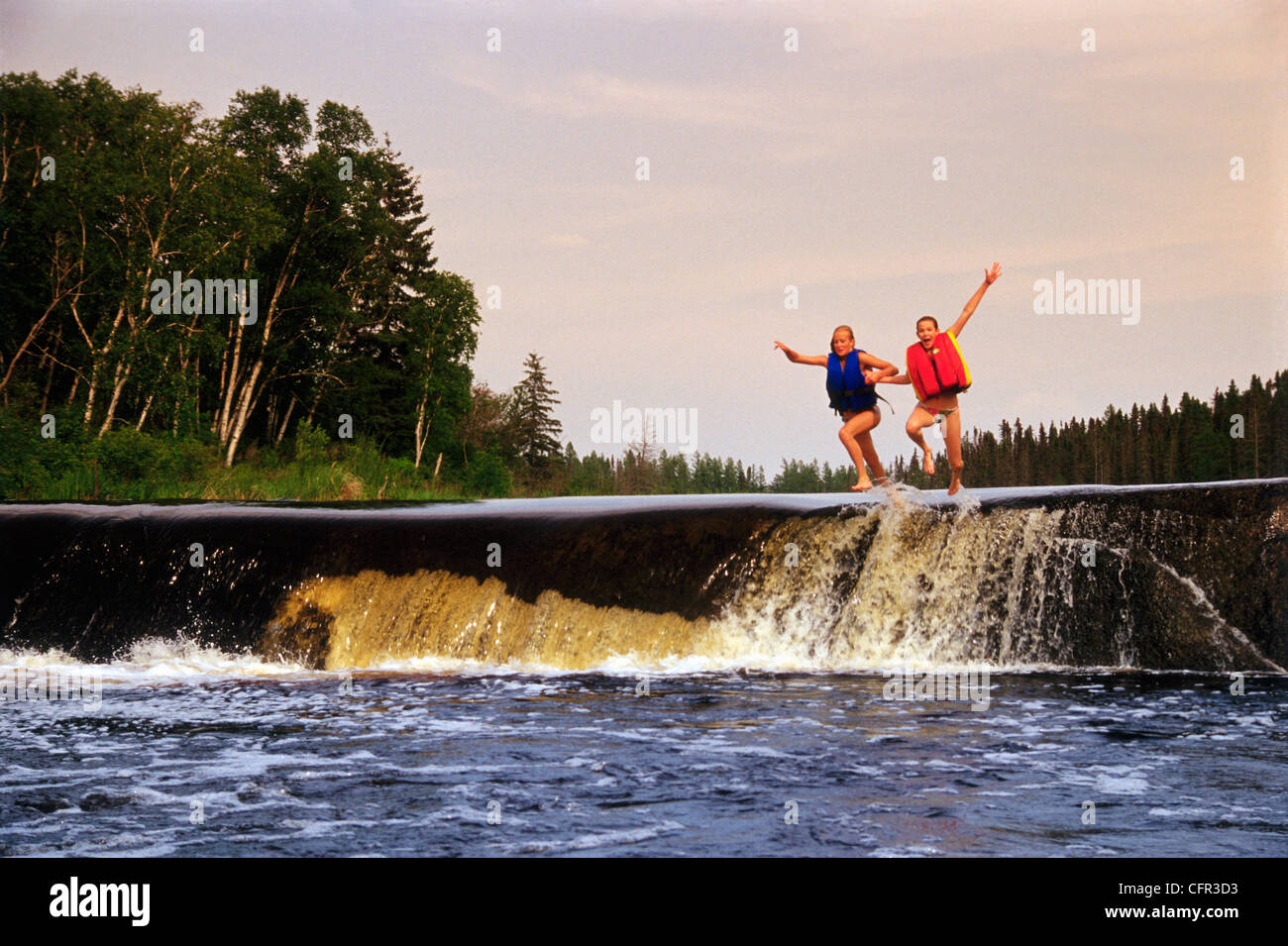 Mädchen (13 Jahre alt) springen in Wasser, Rainbow Falls Whiteshell Provincial Park, Manitoba Stockfoto