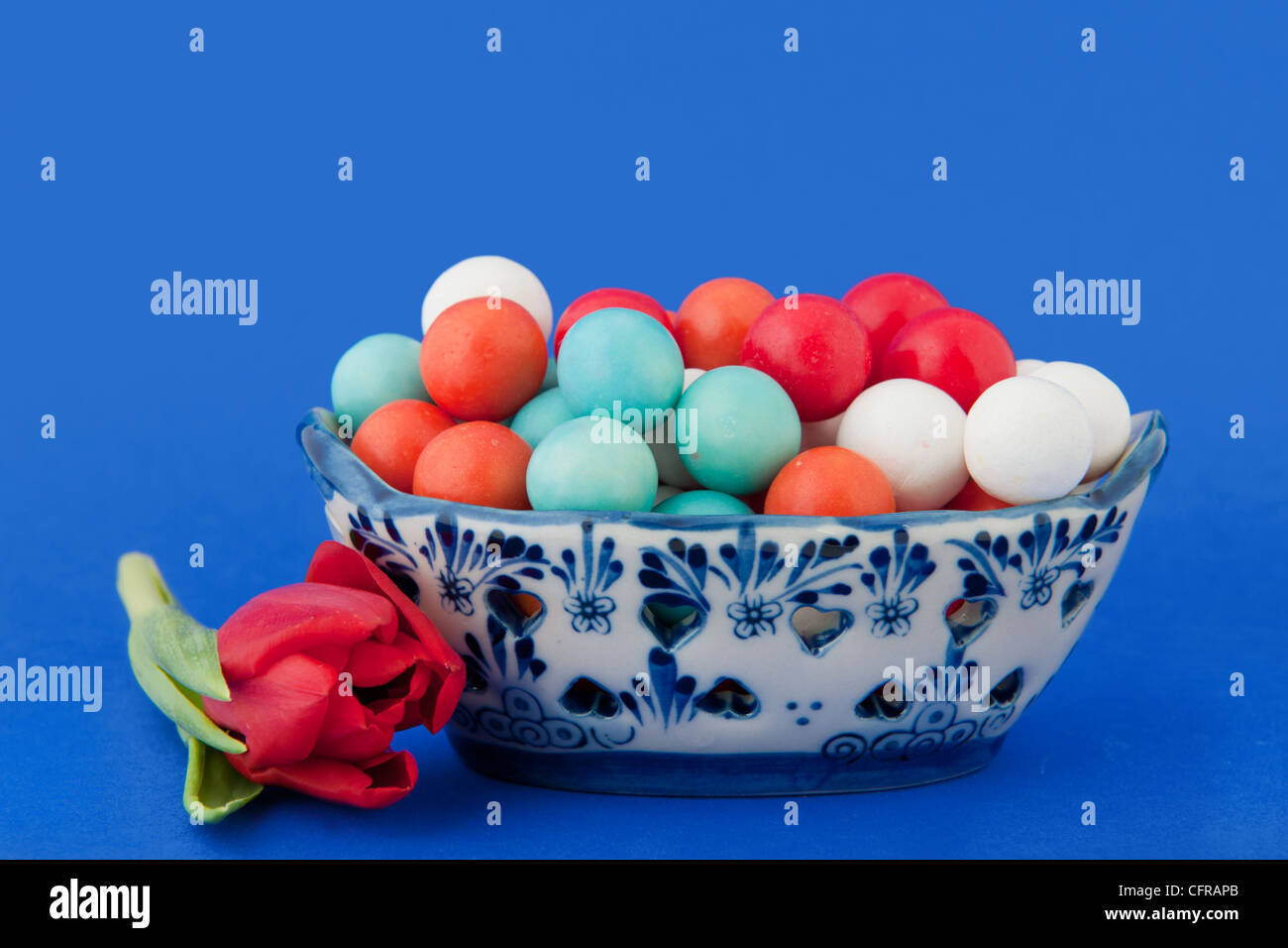 Typische holländische Schale mit Kaugummi Kugeln und rote Tulpe Stockfoto