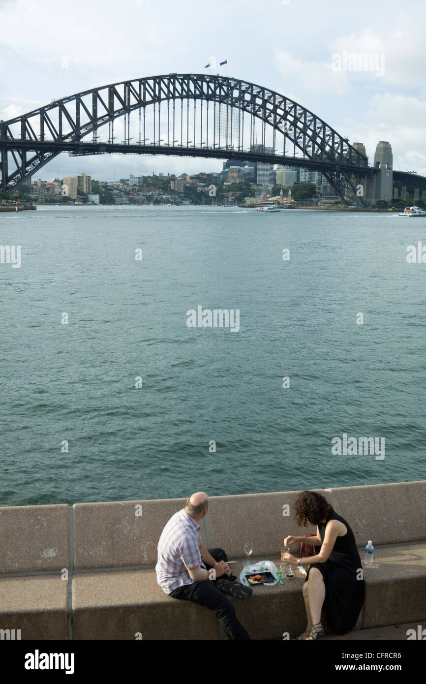 Ein paar, einen Drink mit Blick auf die Harbour Bridge. Sydney, Australien Stockfoto