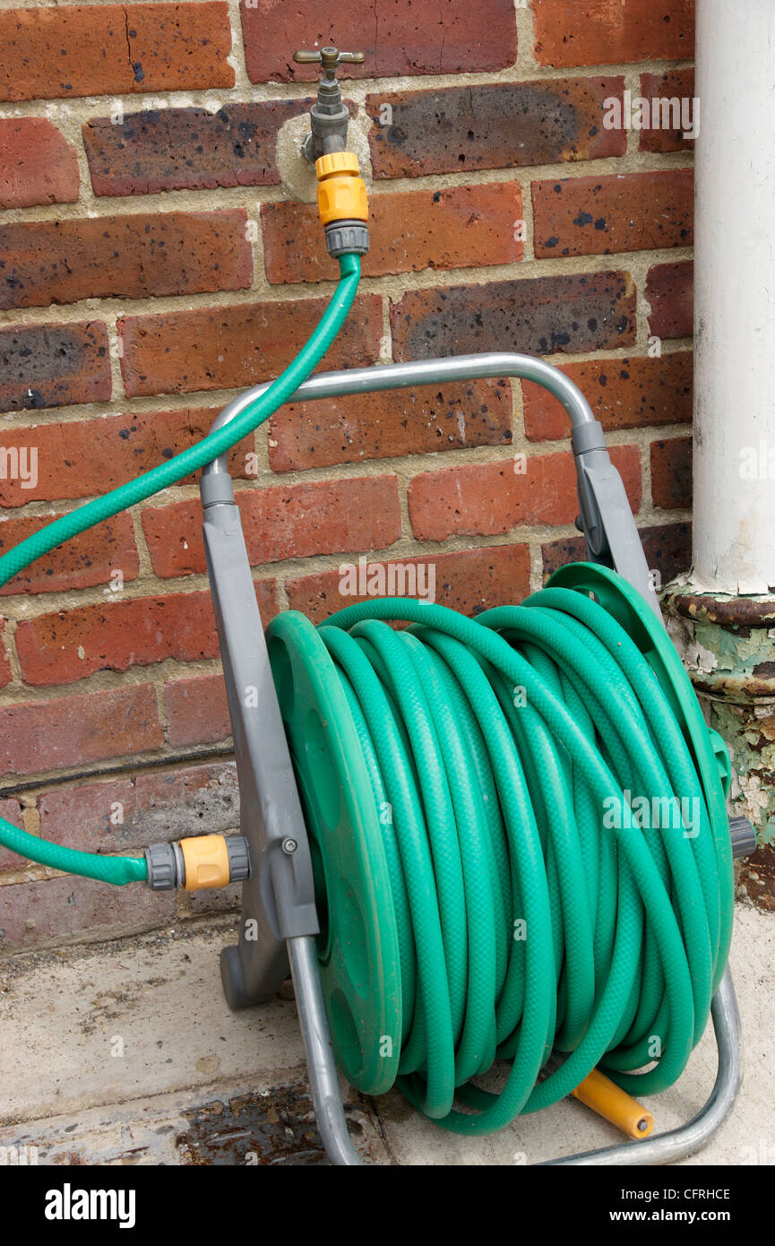 Schlauchleitung auf Walze befestigt, Wasserhahn im Garten mit dem Gartenschlauch-Verbot in Kraft in vielen Bereichen des Landes Stockfoto