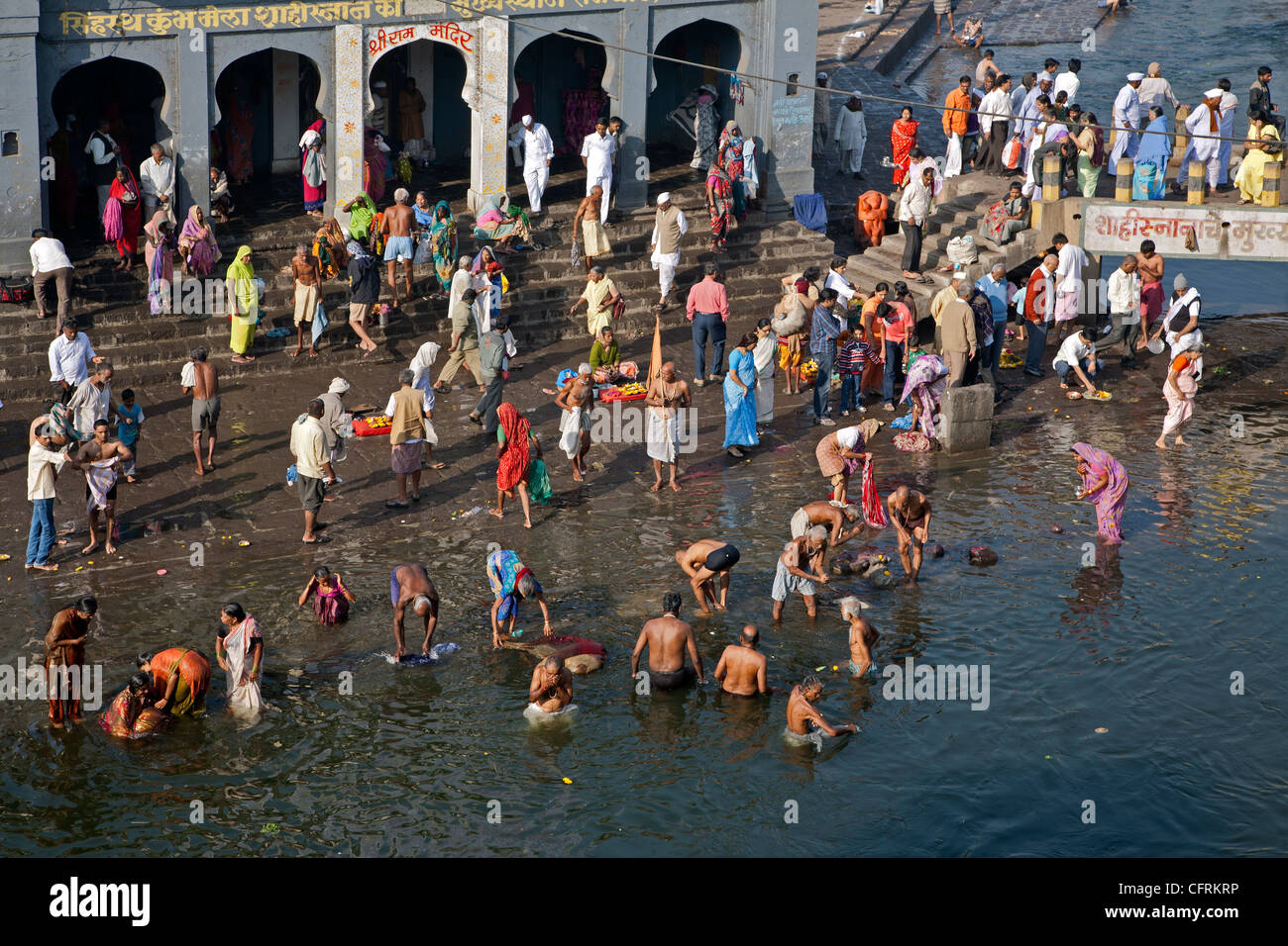 Hindu-Pilger machen das rituelle Tauchbad bei Ram "Kund". Godavari Fluß. Nasik. Indien Stockfoto