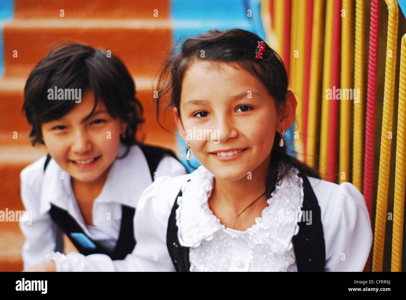 Usbekistan, Fergana, close-up Portrait des Lächelns Schulmädchen auf der Treppe Stockfoto