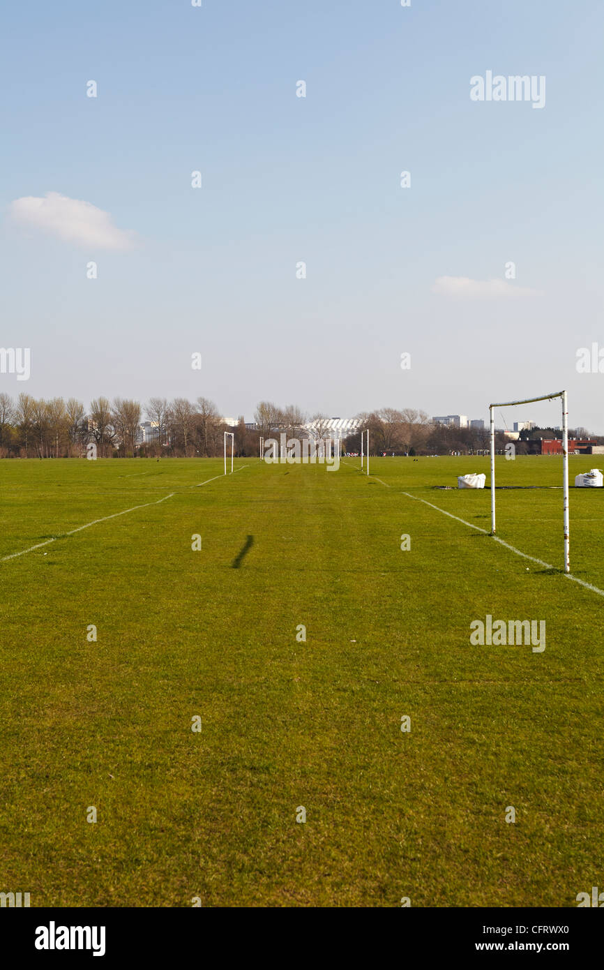 Blick auf den Gehweg zu viele Fußballplätze mit eine Mannschaft spielt im fernen Hintergrund Stockfoto