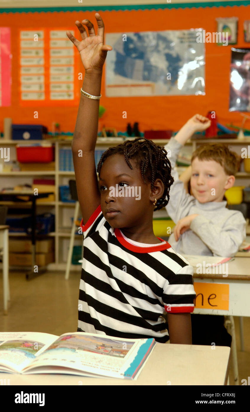Sieben Jahre altes Mädchen, hob ihre Hand im Klassenzimmer Stockfoto