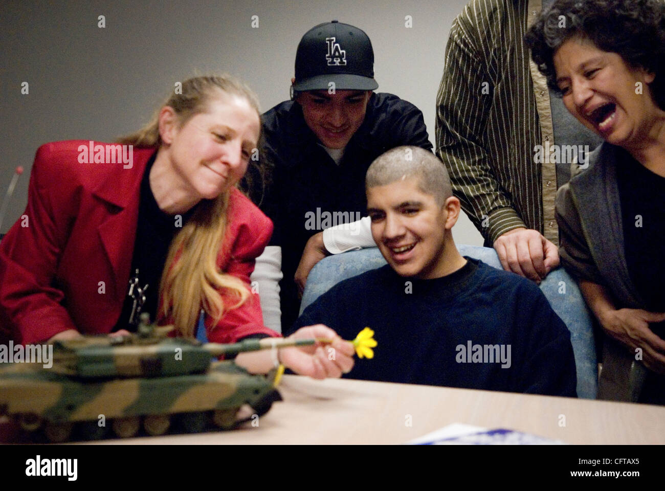 25. Dezember 2006; Sacramento, Kalifornien, USA; JOSH KNIESPECK, Center, lächelt als Freund der Familie, Misako Larkin von Fair Oaks, legt eine Blume in die Pistole ein Spielzeug ferngesteuerte Panzer, der die ihn als Weihnachtsgeschenk gegeben wurde.  Er erhielt ein Zimmer voller Besucher bei UC Davis Hospital 25. Dezember 2006.  Blick auf Stockfoto