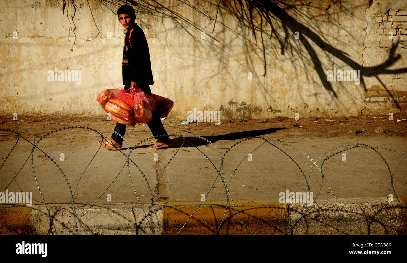 11. Februar 2007 - Siniyah, Salah Ad-Din, Irak - ein irakische Kind trägt einen Beutel mit Brot, während er die Straße runter geht (Credit-Bild: © Andrew Craft/The Fayetteville Observer/ZUMA Press) Stockfoto