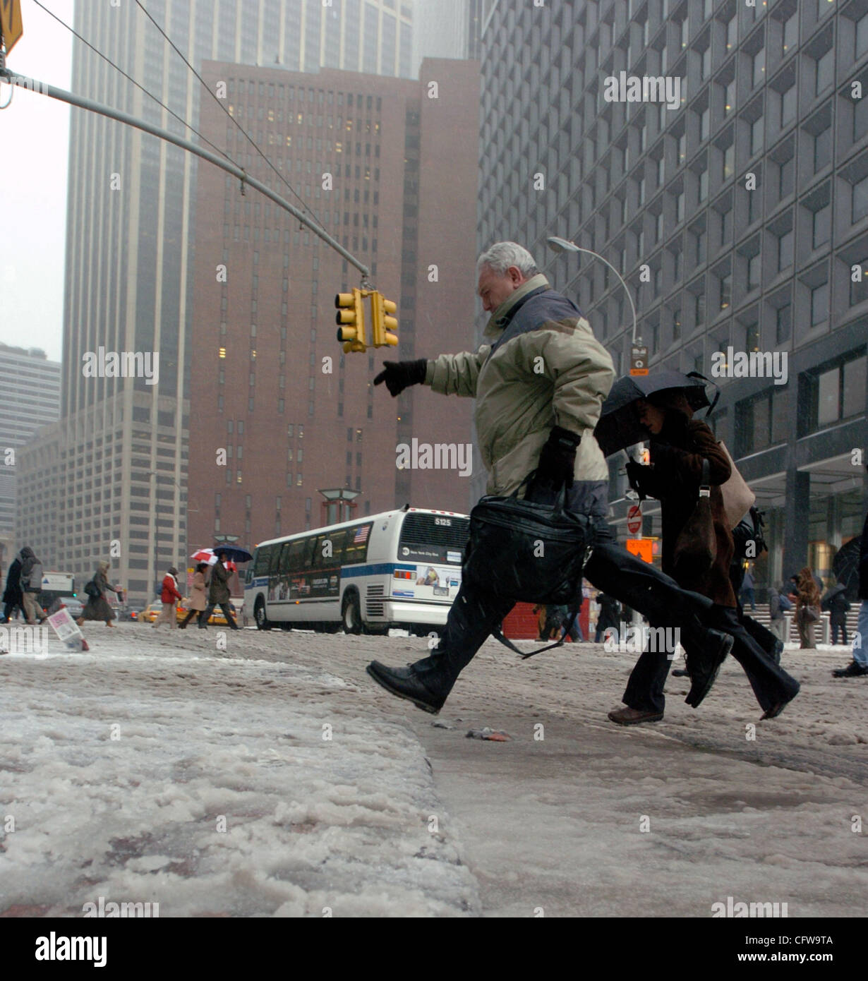 Fußgänger-Hop über Schneematsch Pfützen entlang der Water Street in lower Manhattan als ein Schneesturm New York City trifft. Stockfoto