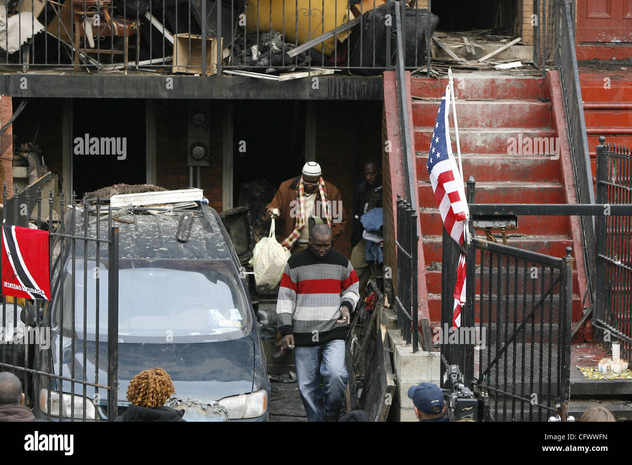 10. März 2007 - Bronx, New York, USA - Mamadou Soumare, 48, ein Taxifahrer, vorne in der Mitte, verlässt 1022 Woodycrest Ave., nach dem sammeln einige persönliche Gegenstände bei seinem ersten Besuch zurück in die Szene ein tödliches Feuer gestern Mittwoch Abend in seinem Haus in der Highbridge Abschnitt der Bronx. Soumare, Hallo verloren Stockfoto