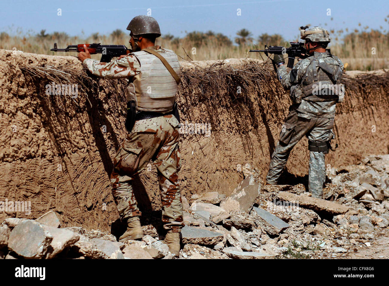 28. März 2007 - Shakarah, Diyala, Irak - eine irakische Armee Soldat und ein US-Soldat scannen den Umfang der Suche nach einem Selbstmordattentäter Auto in Shakarah, Irak, Mittwoch, 28. März 2007. Amerikaner und Iraker arbeiten jetzt zusammen auf jede Patrouille in der Gegend.  (Kredit-Bild: © Nicole Fruge/San Ant Stockfoto