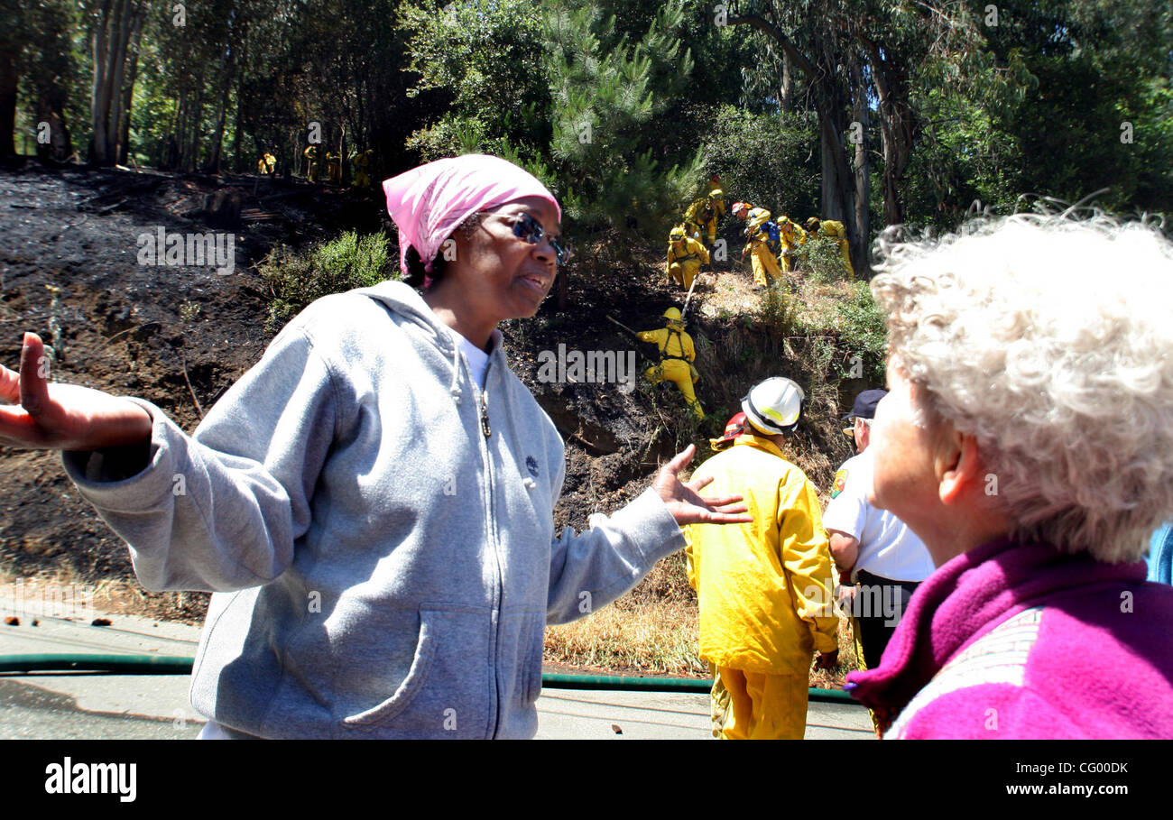 Maryel Norris ein Bewohner von 5900 Block von Balboa Dr. in Oakland Hills, spricht mit ihrer Nachbarin, Adrienne Bryant, über das Feuer, das auf der anderen Straßenseite von ihr und ihr Nachbar Häuser ein wenig vor 01:00 Dienstag, 5. Juni 2007 begonnen.  Oakland Feuer und löschte das Feuer, die geschwärzt CDF Stockfoto