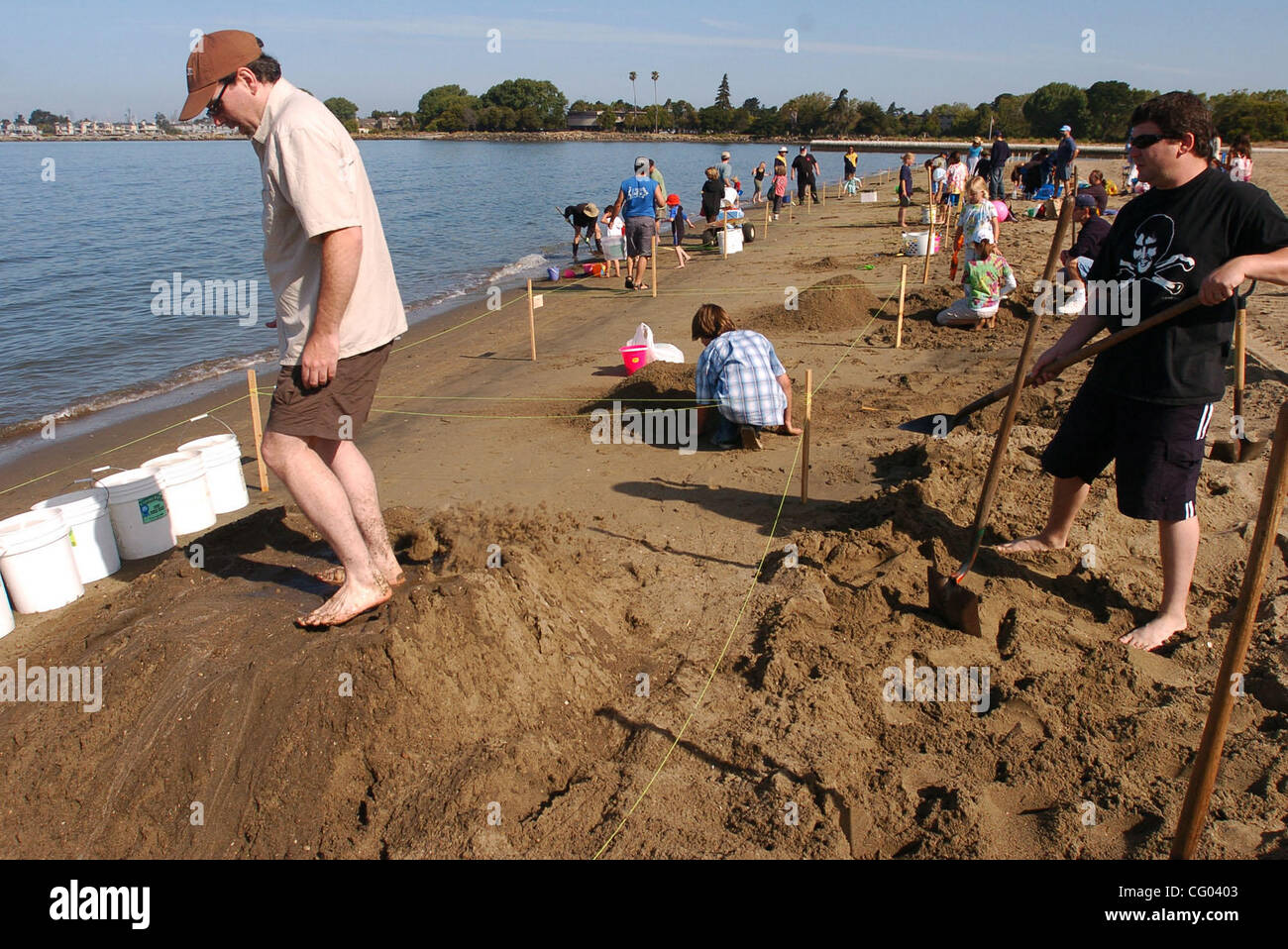 Wie sie ihre Burg beginnen, sand Ryan Sullivan (links) stampft auf dem nassen Sand als Michael McFarland (rechts) Schaufeln mehr auf während der 41. Jahrestagung Sandcastle-Contest auf Samstag, 9. Juni 2007 in Alameda, Kalifornien  Hunderte von Menschen kam 94 Teams, bestehend aus 431 Menschen ansehen, arbeitest du für Gebäude Stockfoto