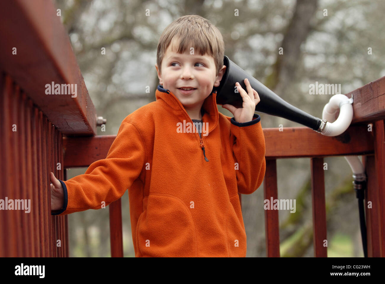 Coltin Sanders, 5, hört seine Schwester Jamie Sanders, 6, durch einen provisorischen Telefon in seinem Hinterhof Spielplatz in Roseville, 8. Februar 2007. Foto von Florenz Low Stockfoto