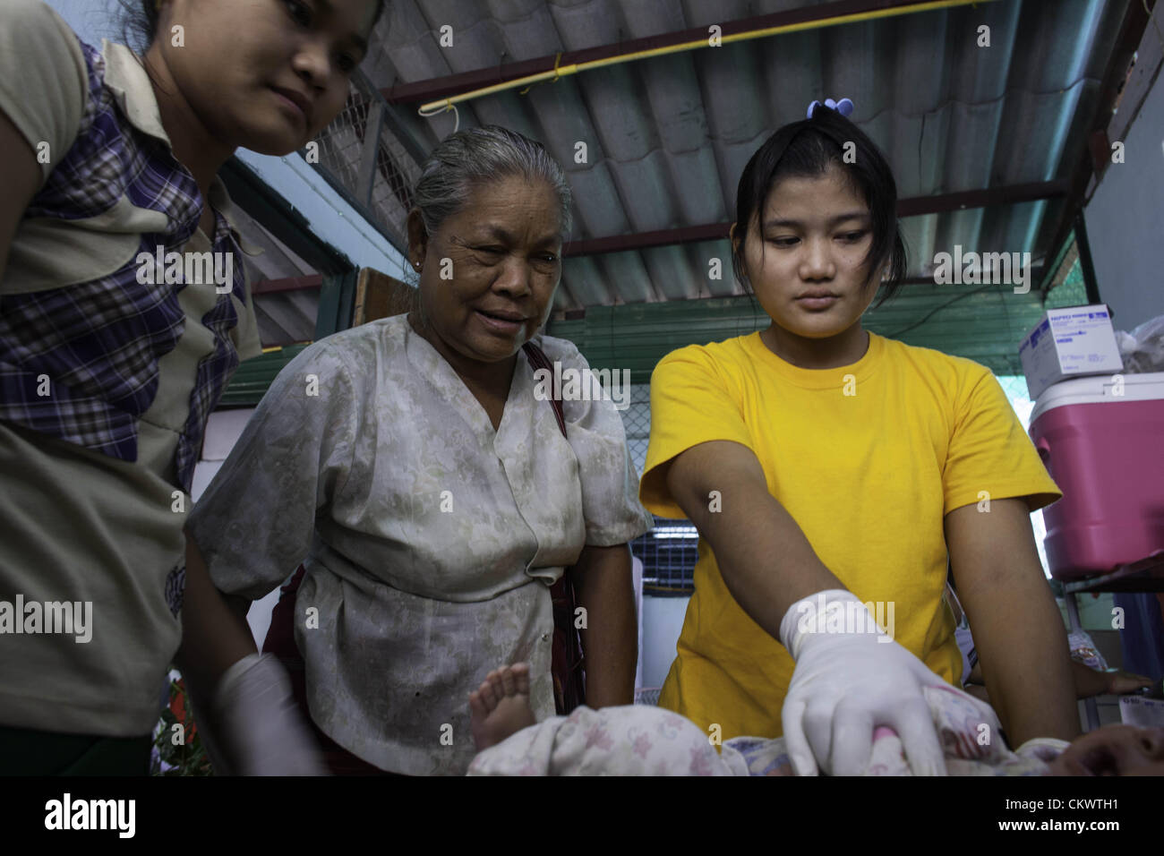 22. August 2012 - Mae Sot, Thailand - burmesischen Migranten suchen Immunisierung für ihre Kinder in Mae Tao Klinik in der Nähe von Mae Sot, Thailand, Mittwoch, 22. August 2012.  Wegen der jüngsten Schritte von International Non-Governmental Organizations-Bewegungen in Burma ist die Mae Tao Klinik, die medizinische Versorgung rund 500 burmesischen Migranten pro Tag zur Verfügung stellt, mit Finanzierungsproblemen konfrontiert. 1989 war von ethnischen Karen Arzt Dr. Cynthia Maung die Klinik als direkte Antwort auf die Bedürfnisse von Tausenden von Flüchtlingen gegründet, die nach Thailand geflohen waren nach einer gewaltsamen Vorgehens gegen prodemokratischen Demonstrationen in Rangoo Stockfoto