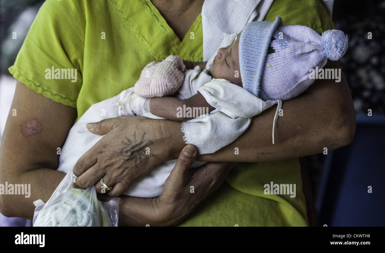 22. August 2012 - Mae Sot, Thailand - burmesischen Migranten suchen Immunisierung für ihre Kinder in Mae Tao Klinik in der Nähe von Mae Sot, Thailand, Mittwoch, 22. August 2012.  Wegen der jüngsten Schritte von internationalen nicht-Regierungs-Organisationen aus der thailändischen Grenze, in Burma, die Mae Tao Klinik, die medizinische Versorgung rund 500 burmesischen Migranten pro Tag zur Verfügung stellt, ist Finanzierungsproblemen konfrontiert. 1989 war von ethnischen Karen Arzt Dr. Cynthia Maung die Klinik als direkte Antwort auf die Bedürfnisse von Tausenden von Flüchtlingen gegründet, die nach Thailand geflohen waren nach einem gewaltsamen Vorgehens auf Pro-Demokratie-Dämonen Stockfoto