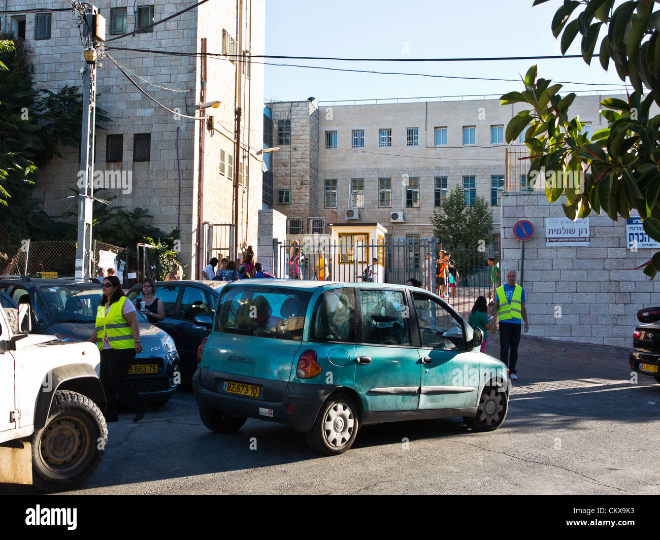 27. August 2012. Eltern tragen helle Westen freiwillig bei der Verkehrsüberwachung und Kursteilnehmer sicheren Zugang auf Bet-Hakerem Grundschule am ersten Tag des laufenden Schuljahres. Jerusalem, Israel. 27. August 2012.   Israelische Kinder gehen wieder zur Schule heute, Abschaffung der traditionellen Sept. 1. Datum, in einer ersten Stufe des Ministeriums für Bildung mit dem Ziel, die Sommerferien 6 Wochen verkürzen eingeleiteten Reformen teilweise entlastet Eltern enorme finanzielle Aufwendungen. Stockfoto